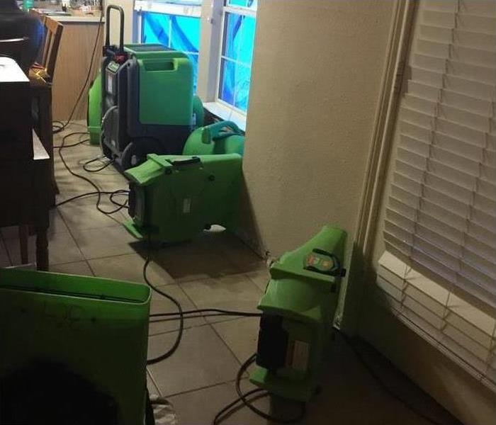 Air movers being used to clean up water damage in a home.
